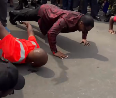 Lazarus Chakwera wear one red shirt and black trousers dey do push-ups for street.