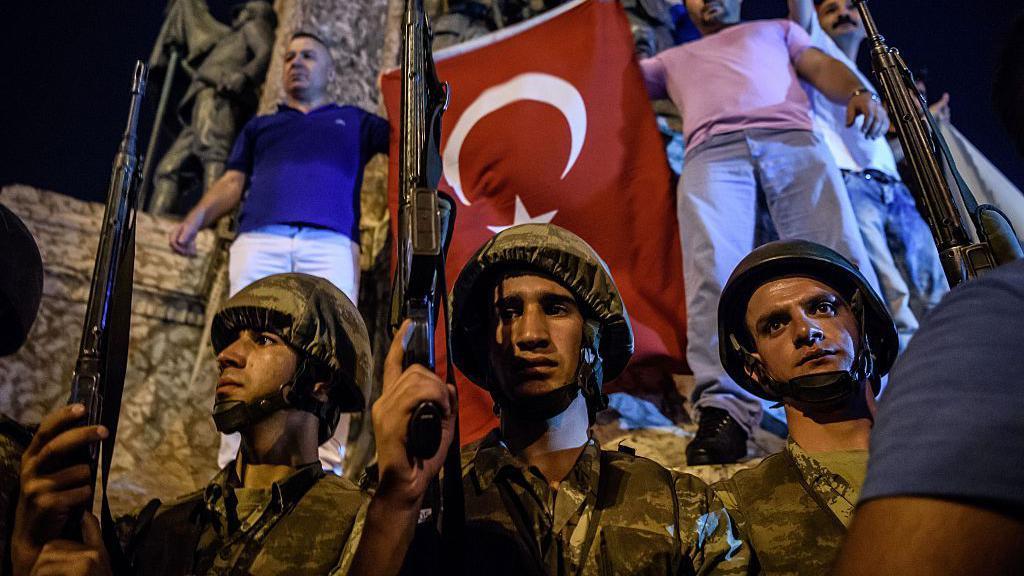 Turkish solders stand wit guns at Taksim square as pipo react for Istanbul on July 16, 2016. 