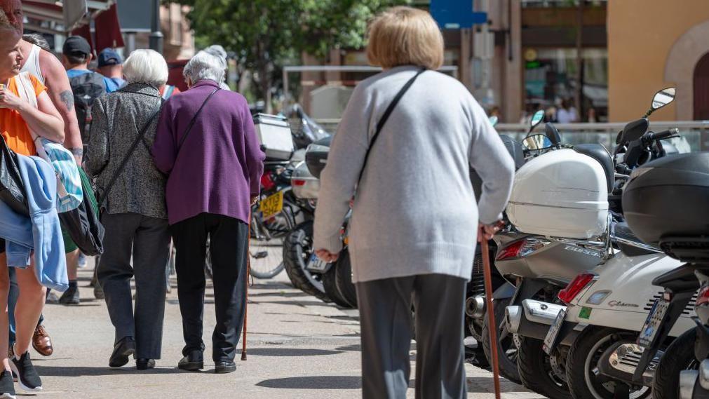 Elderly women for Mallorca dey waka wit sticks