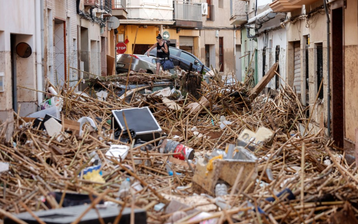 A resident walks over debris in the flood-hit municipality of Paiporta, in the province of Valencia, Spain, on 30 October 2024