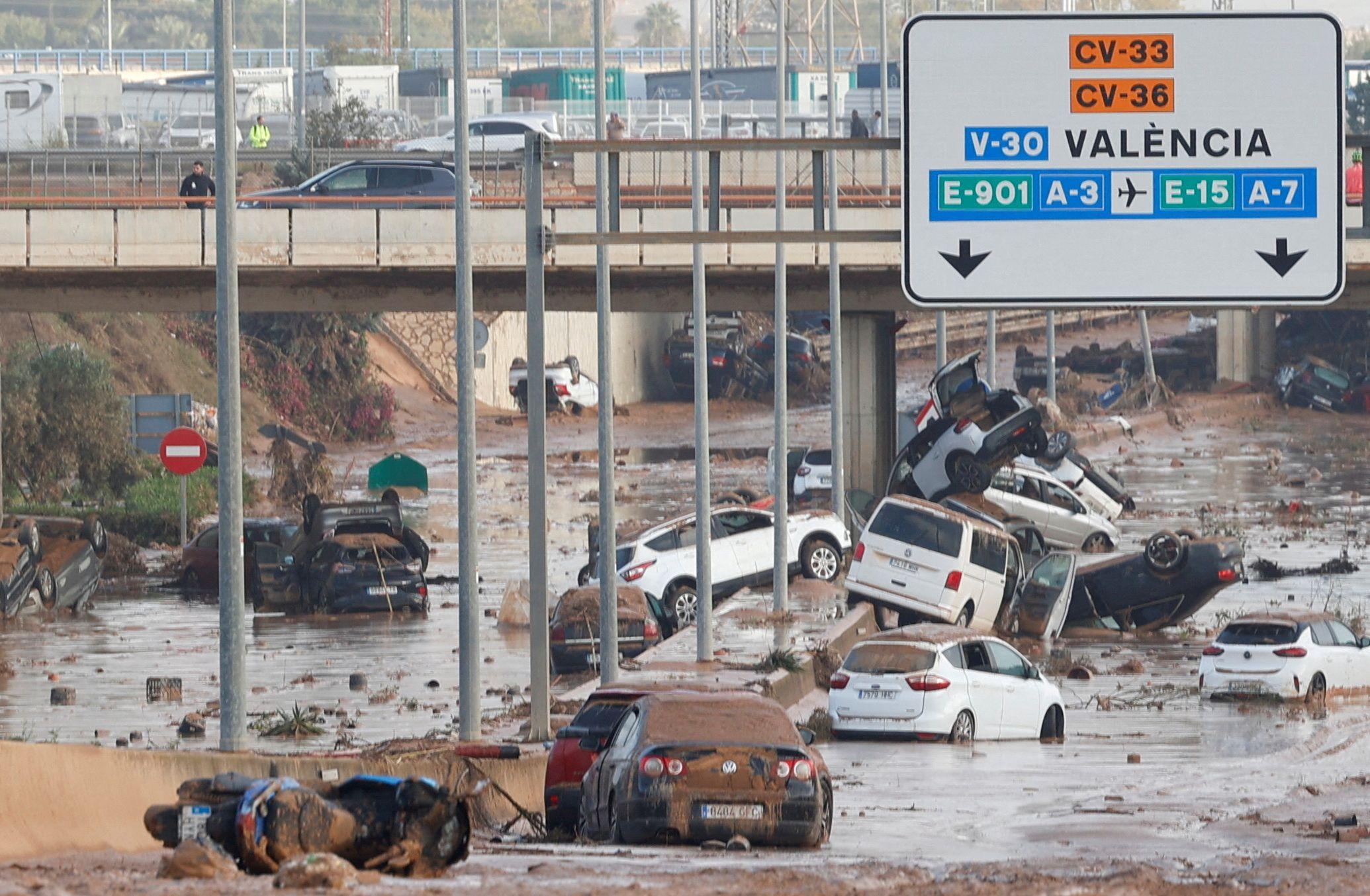 Damaged cars are piled up along a road affected by torrential rains that caused flooding, on the outskirts of Valencia, Spain, on 31 October 2024