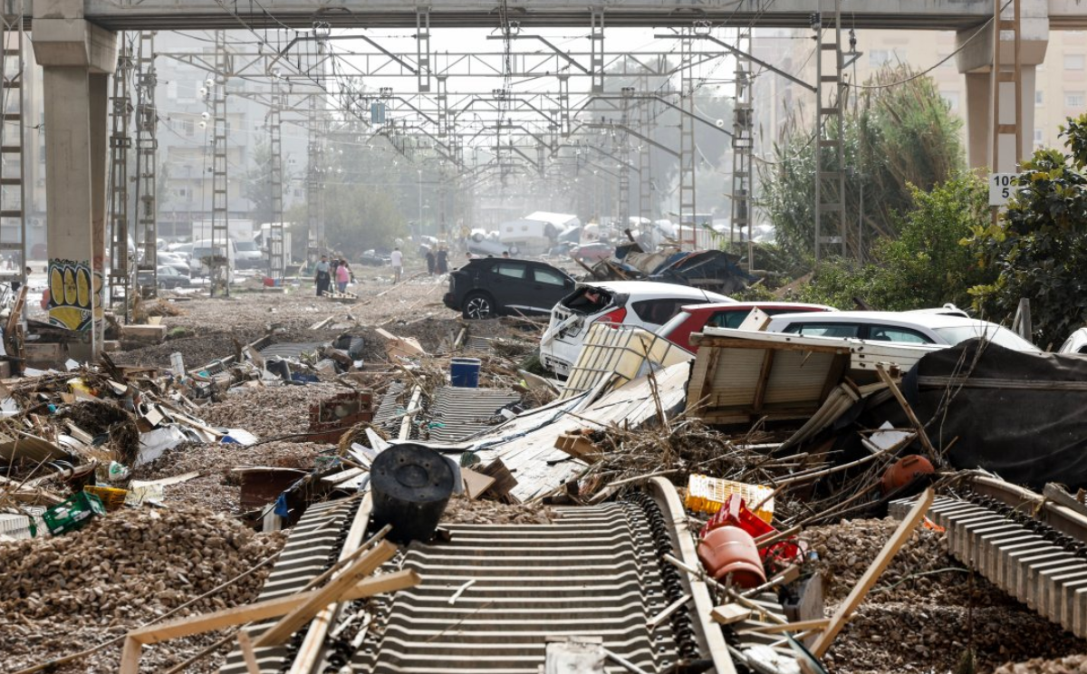 Cars and debris on top of twisted railway tracks