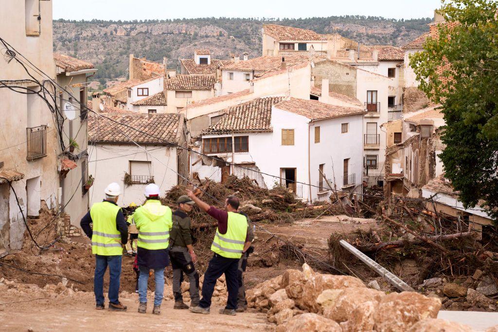 Men in high visibility jackets in front of debris